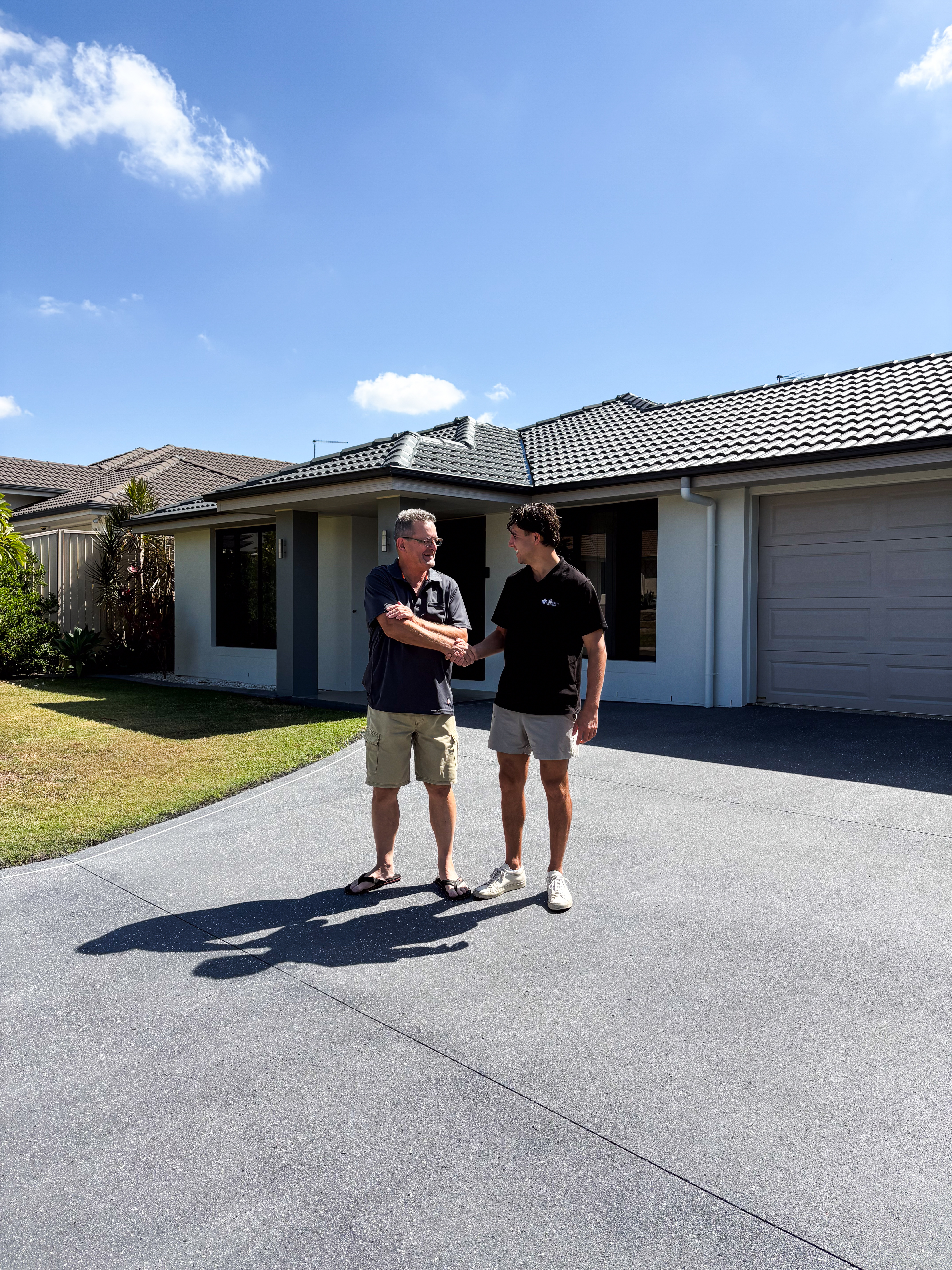 Lachlan from CoatPro shaking hands with a happy customer on their freshly sealed driveway