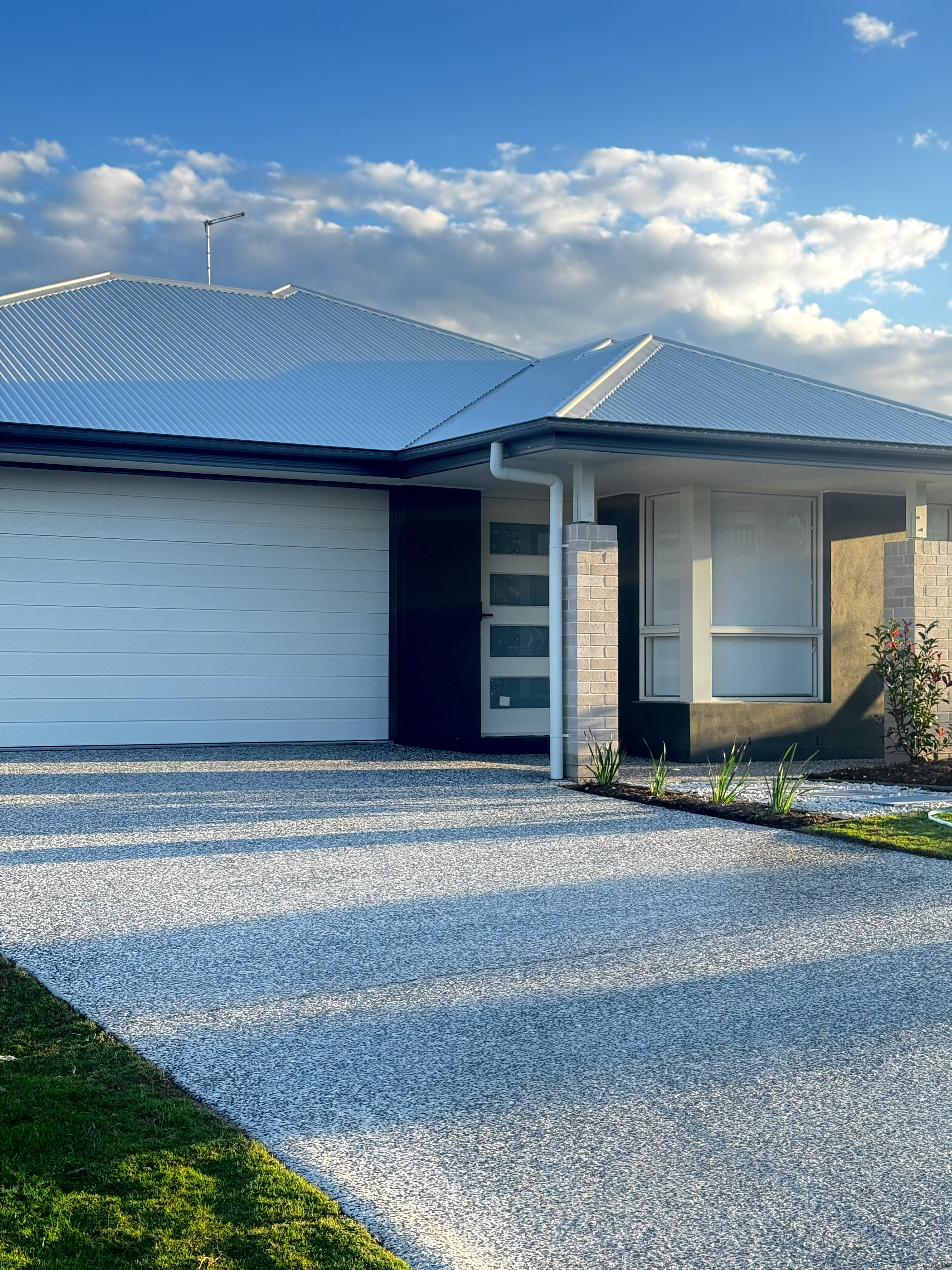 Freshly sealed exposed aggregate driveway with a sleek finish