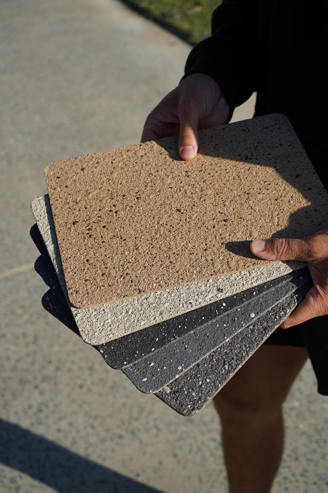 CoatPro applicator showing spraycrete colour sample boards during a free on-site assessment
