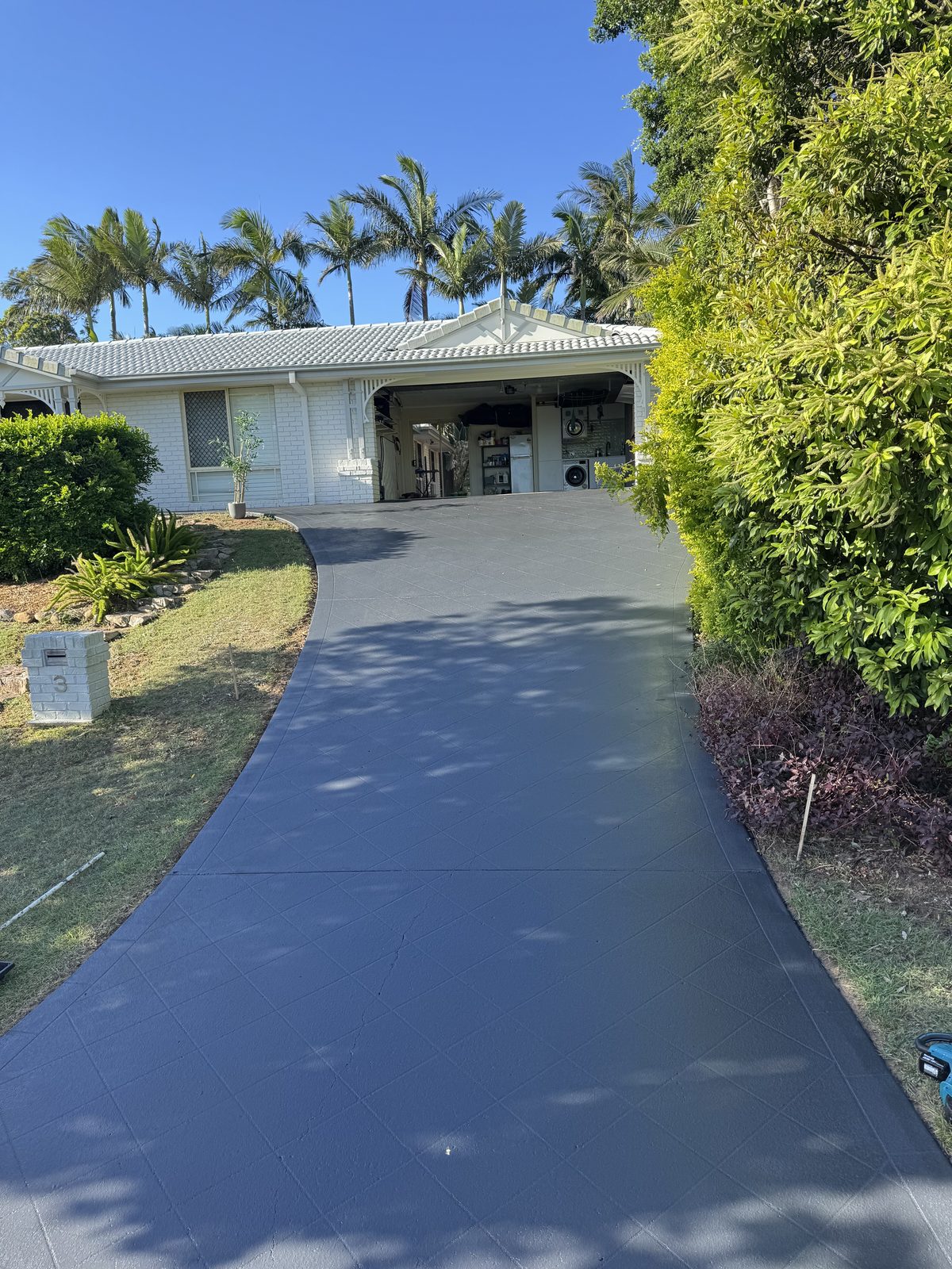 The same stencilled driveway resealed in charcoal