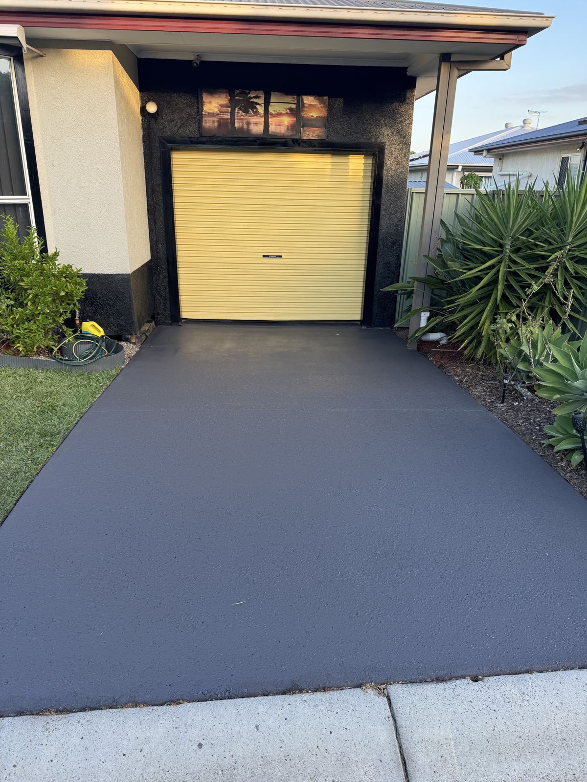 After: the same driveway coloured sealed in Storm Grey